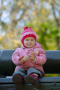 坐在公园长凳上的小女孩图片