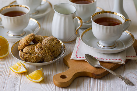 茶会美的装饰桌配有杯子酱汁茶叶和燕麦饼干图片