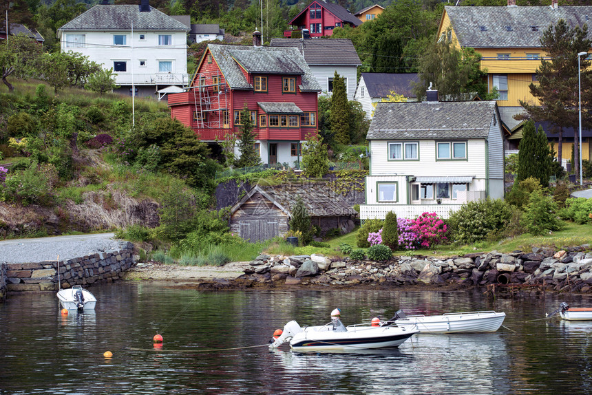 传统的挪威木制房屋站在湖边和山的偏远北图片
