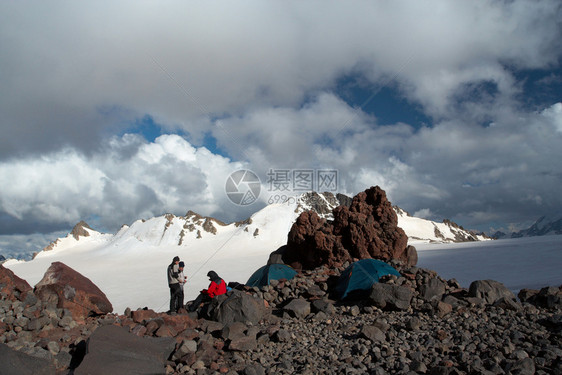 在山营帐篷附近休息的徒步旅行者图片