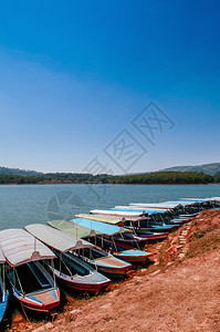 著名的传统木制旅游船在Tiyenlam湖或位于dltvienam的hotuyenlamke或ho春季有蓝天和山图片