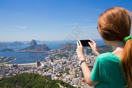 观光女游客用智能手机拍下一张照片图片