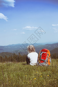 青年女孩背着包徒步旅行在山地和森林之间图片