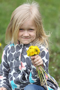 金发小女孩在绿草坪上背景图片