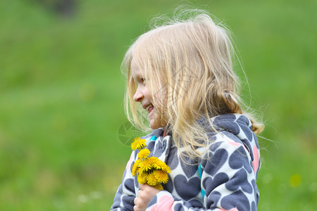 金发小女孩在绿草坪上图片
