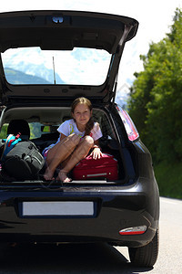 年轻女孩在汽车后备箱的肖像图片