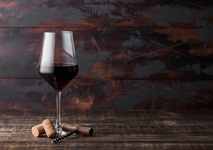 高雅的红酒杯深黑木制背景的软和杯图片
