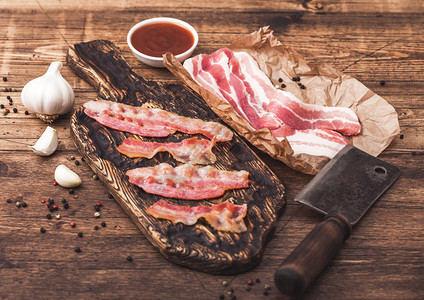 在旧木板上加烤培根条在屠夫纸上加生鲜熏猪肉培根在木板上加肉斧图片