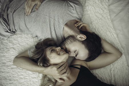 幸福的一对情侣在床上接吻图片