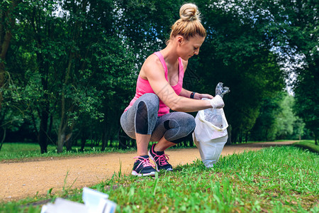 蹲着的女孩捡垃圾环保概念图片素材