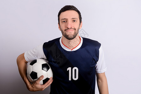 年轻人的肖像与足球在工作室体育概念图片