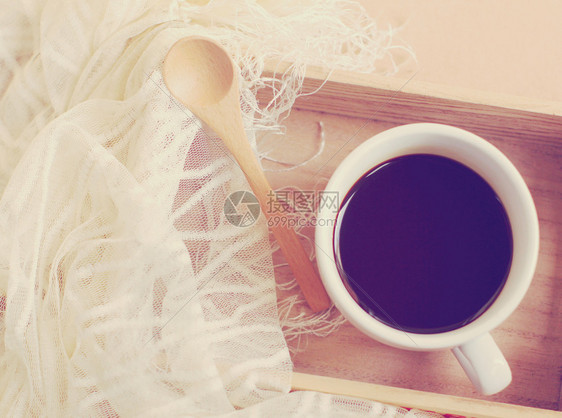 丝围巾黑咖啡和木托盘上的勺子反转过滤效应图片
