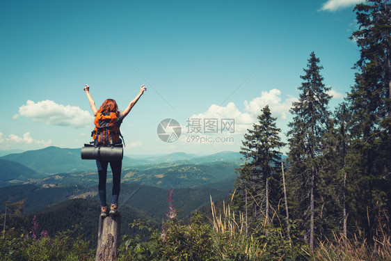 在山林背景上站着包的女孩徒步旅行者尼风景图片