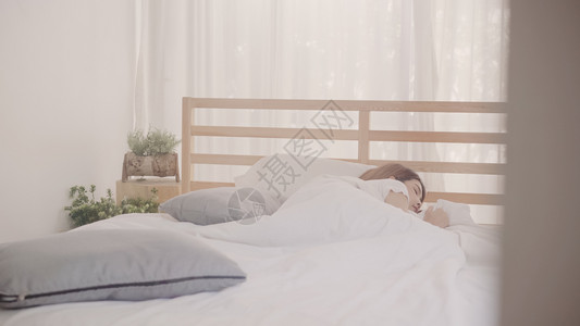 睡在卧室的床上时做梦亚洲女睡在床上的日本女躺在床上休息的日本女在家庭概念中使用放松时间的生活方式女在家庭概念中使用放松时间的女背景图片