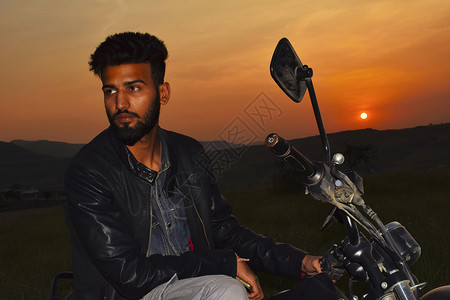 印地安男孩依靠着摩托车图片