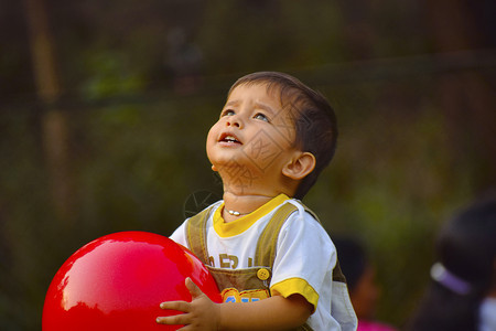 可爱的儿童在花园里玩红色球图片