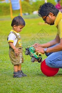 可爱的婴儿和爸爸一起玩玩具车图片