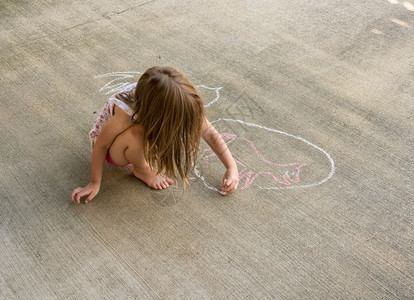 女孩在地面上用粉笔涂鸦图片