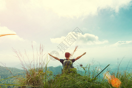 年轻人在天上举起手来快乐地在山上日落感受自由图片