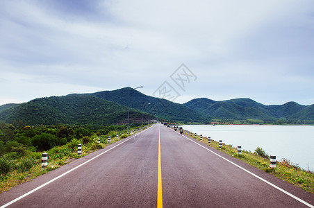 湖边马路一辆黑皮卡在行驶的背景图片