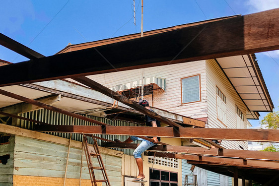 可能1029Chacoengsa泰国古老的木屋利用亚洲劳工在日光天对蓝的木屋顶铁轨结构上摇摆翻修建筑的老木屋图片