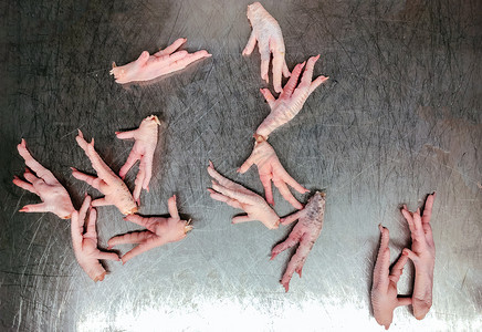 鲜鸡脚爪在老旧不锈桌子上最视图镜头拍摄肉屠宰令人作呕的食物概念图片