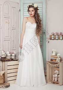 在婚礼浪漫装饰中的年轻新娘粉红色和绿木箱瓶子和不同的结婚装饰图片