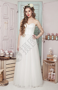 在婚礼浪漫装饰中的年轻新娘粉红色和绿木箱瓶子和不同的结婚装饰图片