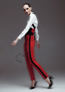 穿着红裤子和灰底白衬衫的漂亮时装模特高清图片