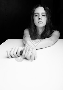 美丽的女孩用优雅手白色立方体在黑背景图片