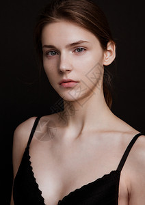 模型测试肖像以年轻的美丽时装模特在灰色背景上黑胸罩和裤子图片