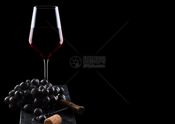 玻璃红葡萄黑色旧的软木瓶开器黑底木板上的软图片
