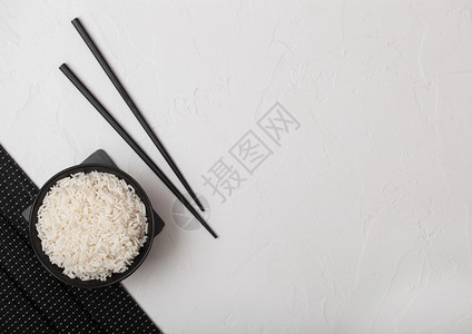 白碗有煮的机巴斯马蒂茉米饭白底的竹子垫上有黑筷图片