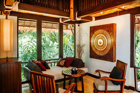 2014年5月日014年月2日泰国Krabi泰国亚裔豪华风格酒店客厅配有当代木制家具椅子桌枕头和泰语风格墙装饰图片