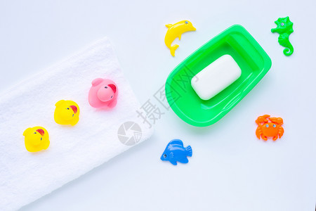白毛巾上的粉色和黄鸭玩具肥皂和海动物白色背景孩子们洗澡的概念图片