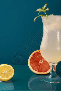 清新软饮料用蓝底的柠檬和葡萄果切片来补充图片
