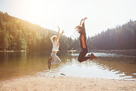 快乐的家庭跳上山湖合欢的海岸图片