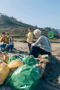 在清理海滩后休息的志愿者图片