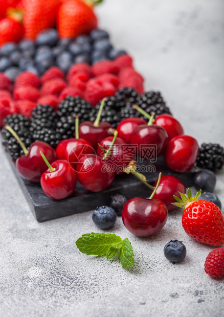 黑大理石板上的浅厨房桌底有草莓蓝黑和樱桃关闭宏图片