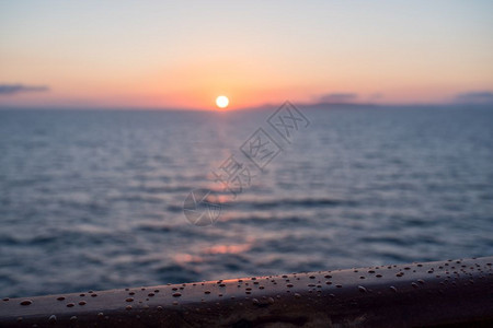 日出或黎明时游轮小在横渡海洋的小游轮茶轨上漂浮着水滴子在日出或黎明时游轮的茶轨上降下雨水图片