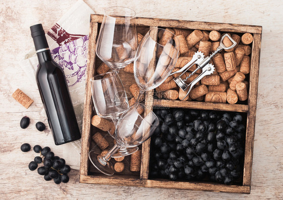 红葡萄酒和杯子空深葡萄木质箱内装有软塞和开瓶器图片