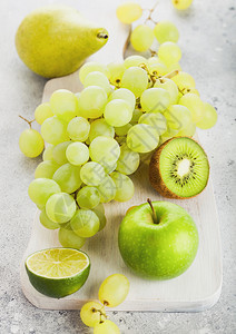 白切纸板上的新鲜有机绿色果实石餐桌背景梨子和葡萄图片