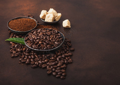 含有地面粉和甘蔗糖的新鲜有机咖啡豆和棕色树叶的甘蔗糖立方体图片