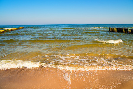 波罗的海腹股沟和冲浪和晴朗的天空波罗的海有丁坝海浪和蓝天图片