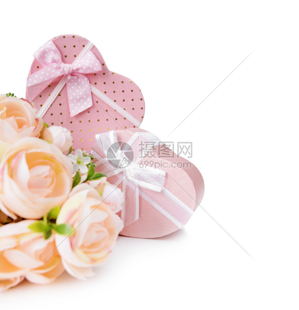 两个粉红礼物盒以心脏形状带有丝弓和花束的粉红骆驼白色背景被孤立图片