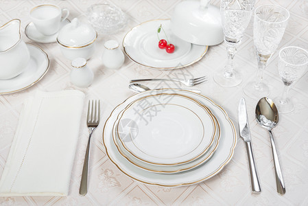 美的装饰桌上面有白色板晶杯水眼镜餐巾布具和樱桃莓以及豪华桌布图片