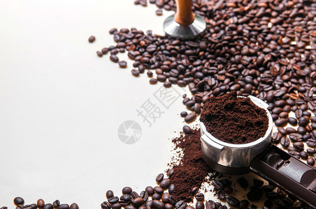 烤焦的阿拉伯咖啡豆在门脚过滤器中的地面咖啡以及一些散落和在白色背景Whit复制空间上模糊的篡改图片