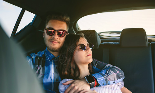 年轻夫妇在汽车后座休息图片