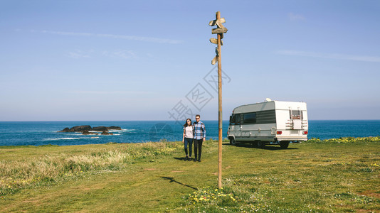 一对夫妇驾驶露营房车在海边停驻休息图片