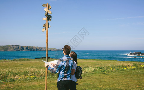 一对年轻夫妇在海岸附近寻找和方向标志一对夫妇在寻找和方向标志图片